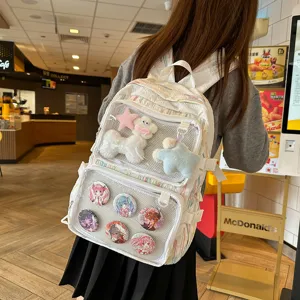 Detail shot of white ita backpack with transparent window, cute plushies and anime badges inside.