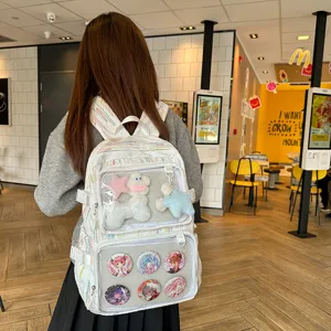 Detailed view of the cute ita backpack with transparent window, plush charms and anime pins.