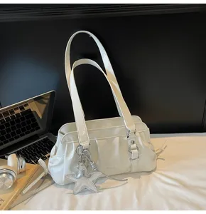 White pleated shoulder bag detail showcasing soft glossy leather and silver star charm.