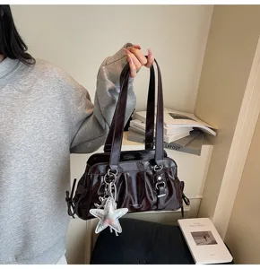Detailed view of dark brown slouchy shoulder bag featuring chic pleated texture and star charm.