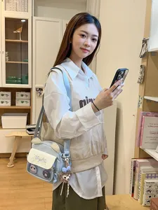 Détail de sac bandoulière ita mignon avec poche en filet transparente et charm en peluche.