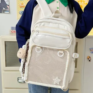 Detail view of large capacity white ita backpack with transparent pocket and cute bear pendant.