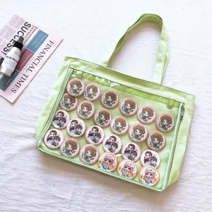 Japanese canvas ita bag detail showcasing clear display window and cute anime character badges.