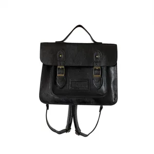 Détail de sac à dos rétro en cuir noir avec boucles métalliques et poignée supérieure.