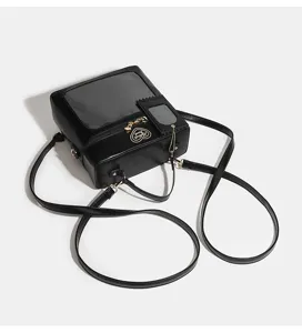 Detail view of black Ita bag with clear display window, handle and straps, premium design.