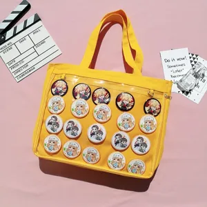 Yellow canvas ita bag detail with clear front pocket decorated with cute anime character pins.