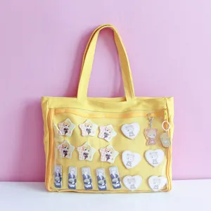 Japanese style yellow canvas ita bag with clear front pocket for anime pins and badges daily use.