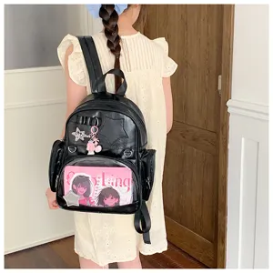 Vue détaillée du sac à dos ita en cuir PU noir avec poche avant transparente et breloques.