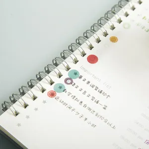 Spiral planner notebook with colorful dot washi tape stickers for daily schedule planning.