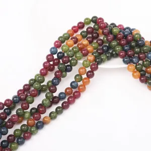 Primo piano di fili di perle di gemme colorate, superficie lucida, gioielli fai da te.
