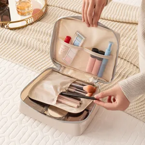 Detailansicht der beigen Reise-Kosmetiktasche mit Netztaschen und Pinselhaltern für einfache Organisation.