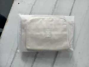Beige travel storage bag detail, portable folding organizer pouch with durable zipper design.