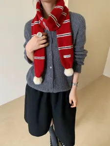 Cozy red knit striped scarf with cute white pom poms, stylish winter warm neckwear for women.