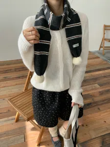 Cozy knitted striped scarf with pom poms for women, stylish winter warm neckerchief accessory.