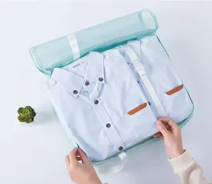 Vista detallada del organizador de ropa de viaje con camisas azules y malla para empacar fácilmente.