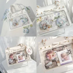 Detail view of white ita bag with transparent window, bow accent, and anime badge inserts.