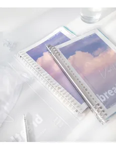 Primer plano detallado de cuaderno de anillas transparente con diseño de nubes.