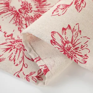Vista dettagliata di un runner da tavola in lino con stampa e ricamo di peonie rosse.