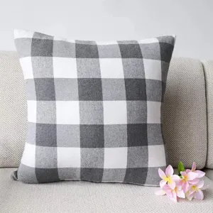 Grey and white buffalo check throw pillow cover, detailed scene on a comfortable sofa.