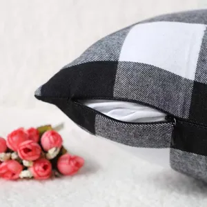 Black and white buffalo plaid cushion cover detail showing fabric texture and neat zipper close.