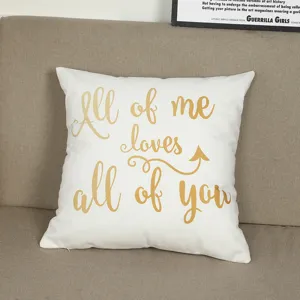 White decorative cushion cover featuring gold romantic text displayed on a sofa detail.