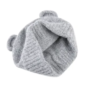 Detailed view of grey knitted beanie with cute bear ears, soft winter warm woolen hat.