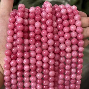 Close-up detail of pink natural stone round bead strands for DIY jewelry and bracelet making.