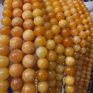 Detail shot of natural stone optimized round loose beads in vibrant yellow, jewelry making DIY.