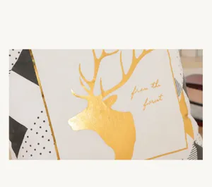 Close-up detail of soft breathable fabric and gold foil deer pattern on the cushion cover.