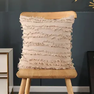 Boho style cotton fringe pillow cover detail showing textured fabric and chair display.