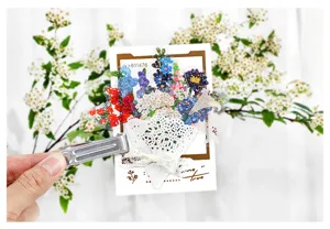 Close-up of decorative floral PET sticker card and metal clip with delicate bouquet design.
