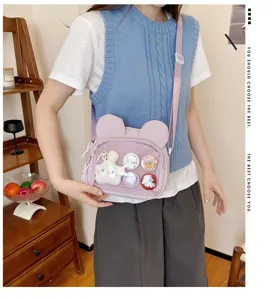 Lila Ita-Tasche mit Hasenohren, transparenter Fronttasche und niedlichen Pins für jeden Tag.