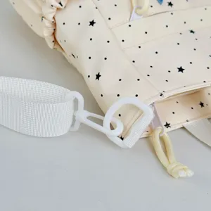 Detailed shot of cute Japanese polka dot backpack strap and buckle in beige color.