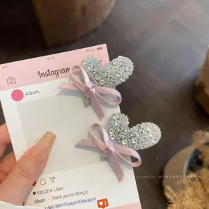Close-up detail of rhinestone heart hair clips featuring elegant pink bows for cute styling.