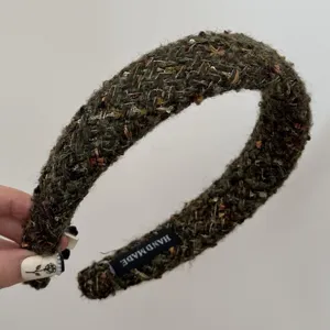 Detailed view of the olive green tweed braided padded headband with handmade label.