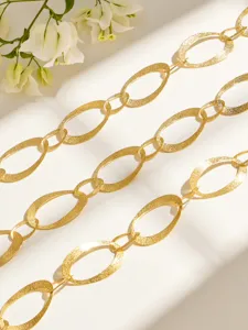 Detailaufnahme der vergoldeten matten ovalen Kettenglieder, elegante Textur und Design.