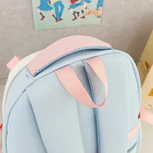 Vue détaillée de la poignée supérieure et des bretelles du sac à dos mignon pour étudiant bleu pastel.