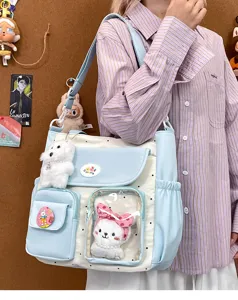 Detailed view of large canvas colorblock shoulder bag, cute style tote with plush toy charms.
