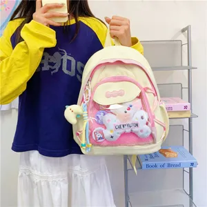 Detailed shot of a cute ita backpack with transparent front pocket, plush toy, and pins.