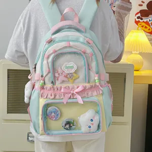 Détail du sac à dos Ita transparent présentant de jolies épingles, pendentifs et nœuds pastel.