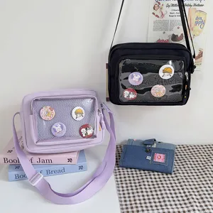 Detail view of Japanese style canvas ita crossbody bag with clear window and cute pin badges.