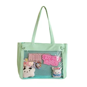 Close-up detail of the light green transparent ita bag featuring cute plush charms and insert cards.