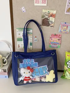 Detailed view of the dark blue ita bag with clear window, featuring cute plush toy and badges.