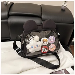 Detailansicht der transparenten Ita-Bag mit niedlichem Plüschstern-Anhänger und bunten Pins.