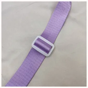 Nahaufnahme Detail eines lila Taschenriemens mit praktischer weißer Kunststoffschnalle.