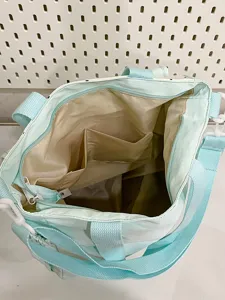 Close up interior view of the color block canvas tote bag showing multiple storage pockets.