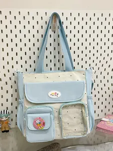 Detailed shot of a cute color-block canvas tote bag with polka dots and multiple pockets.