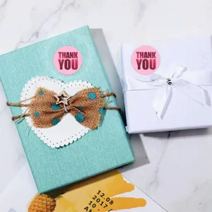 Detailed view of pink thank you foil stickers used for elegant gift packaging and baking seals.
