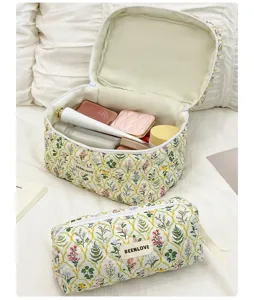 Détail de trousse de maquillage matelassée florale, pochette de rangement zippée mignonne.