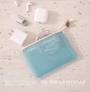 Portable travel mesh storage bag for organizing cosmetics, cables, and daily accessories.